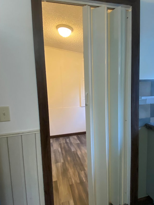 hallway featuring a textured ceiling and hardwood / wood-style flooring