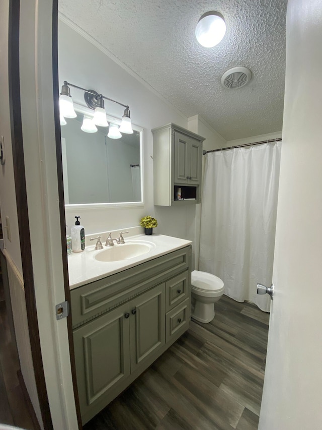 bathroom with toilet, a shower with curtain, hardwood / wood-style floors, vanity, and a textured ceiling