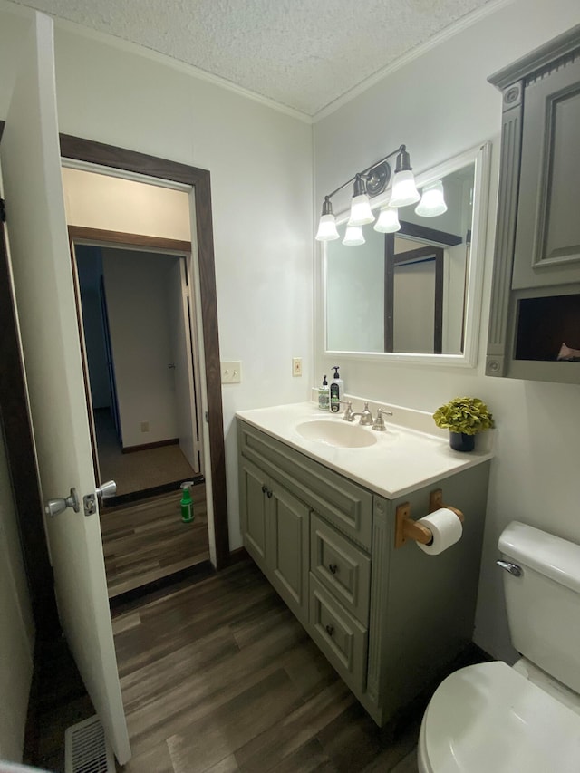 bathroom with vanity, a textured ceiling, toilet, and hardwood / wood-style flooring