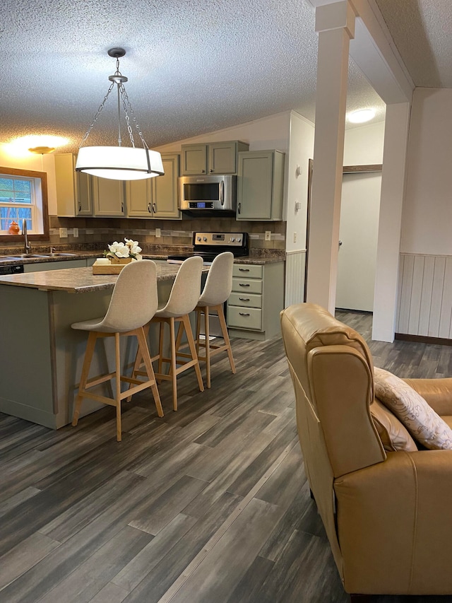 kitchen with a kitchen breakfast bar, dark hardwood / wood-style floors, and hanging light fixtures