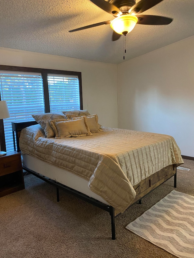 carpeted bedroom with a textured ceiling and ceiling fan