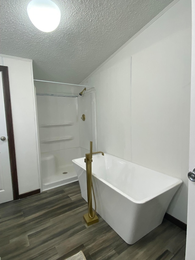 bathroom with separate shower and tub, hardwood / wood-style floors, and a textured ceiling