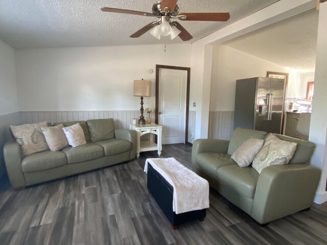 living room featuring lofted ceiling, ceiling fan, a textured ceiling, and dark hardwood / wood-style flooring