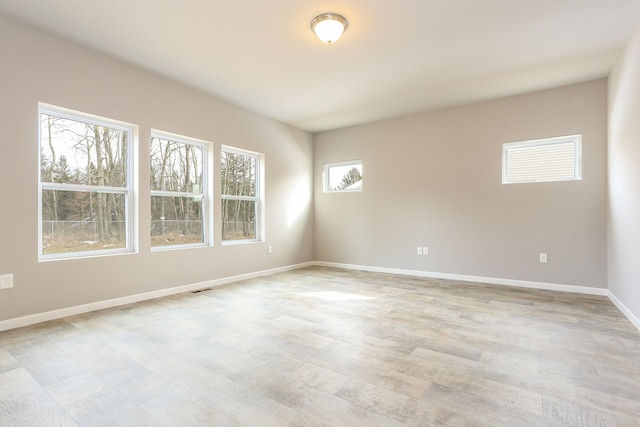 empty room with light wood finished floors and baseboards