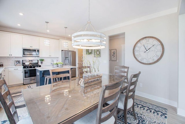 dining space with a notable chandelier and light hardwood / wood-style flooring