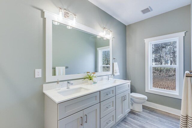 bathroom with vanity, hardwood / wood-style floors, toilet, and a wealth of natural light