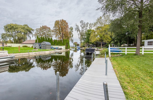 dock area with a water view and a yard