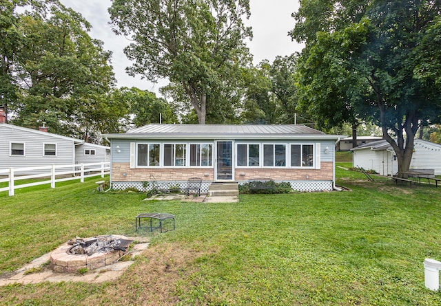 view of front of house featuring a front lawn and an outdoor fire pit