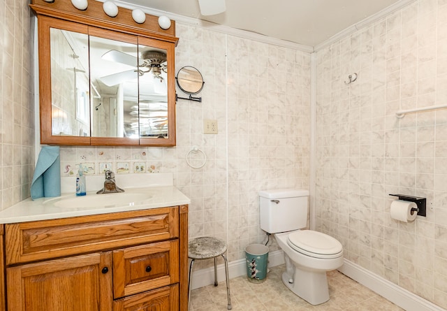 bathroom with tile walls, tile patterned flooring, vanity, and toilet