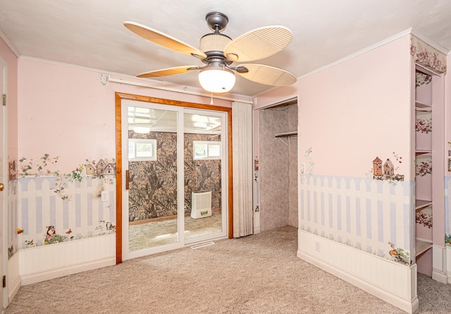 spare room featuring ceiling fan, ornamental molding, and carpet flooring