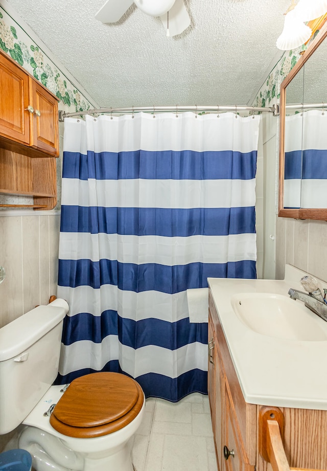 bathroom featuring vanity, a textured ceiling, and toilet