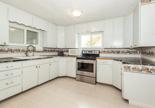 kitchen featuring a textured ceiling, white cabinetry, stainless steel electric range oven, and sink