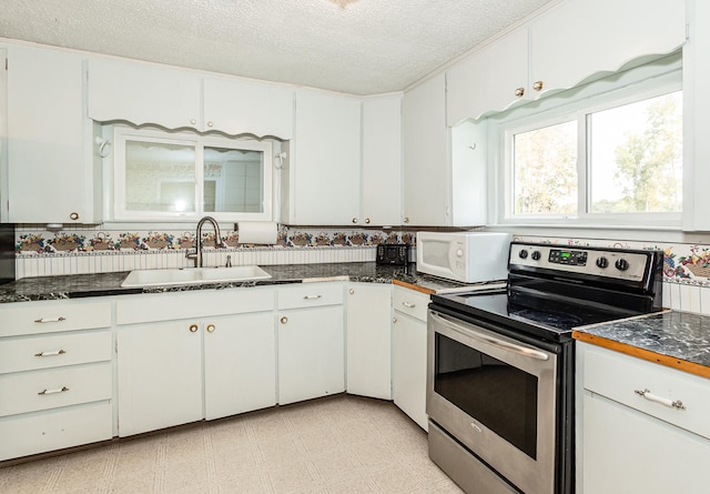 kitchen featuring a textured ceiling, stainless steel electric stove, sink, and white cabinets