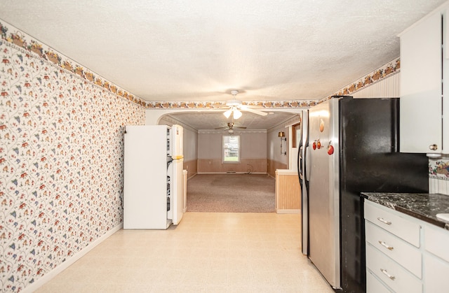 kitchen with white cabinets, stainless steel refrigerator, white fridge, a textured ceiling, and ceiling fan