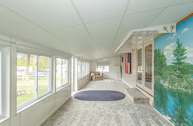 sunroom with a drop ceiling and lofted ceiling