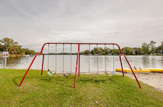 view of playground featuring a lawn and a water view