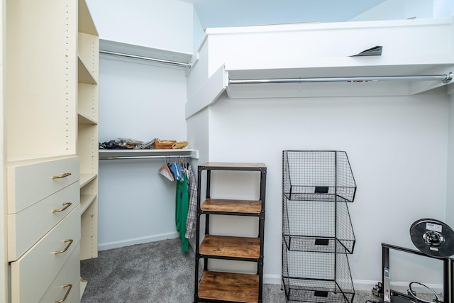 walk in closet featuring dark carpet