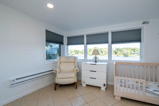 tiled bedroom featuring a baseboard heating unit and a nursery area