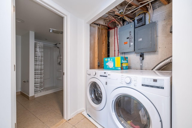 laundry area featuring light tile patterned floors, electric panel, and washer and clothes dryer