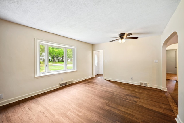 spare room with dark wood-type flooring, ceiling fan, and a textured ceiling