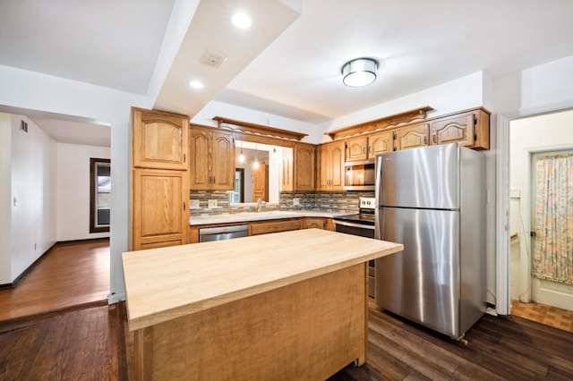 kitchen featuring a center island, dark hardwood / wood-style floors, stainless steel appliances, tasteful backsplash, and sink