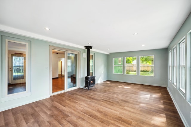 unfurnished living room with light hardwood / wood-style flooring and a wood stove