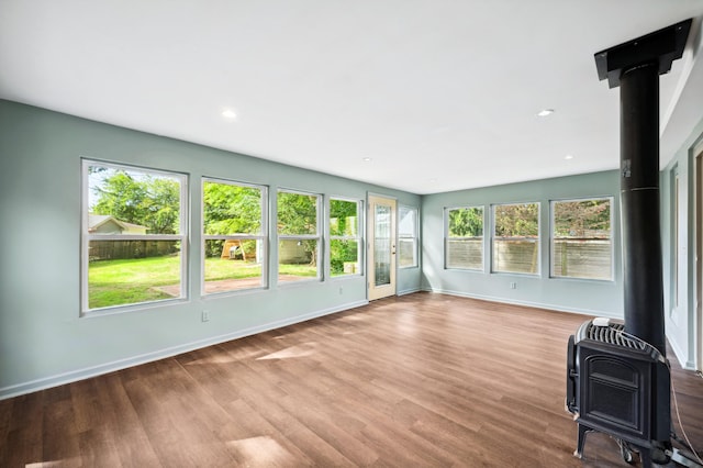 unfurnished sunroom featuring a wood stove