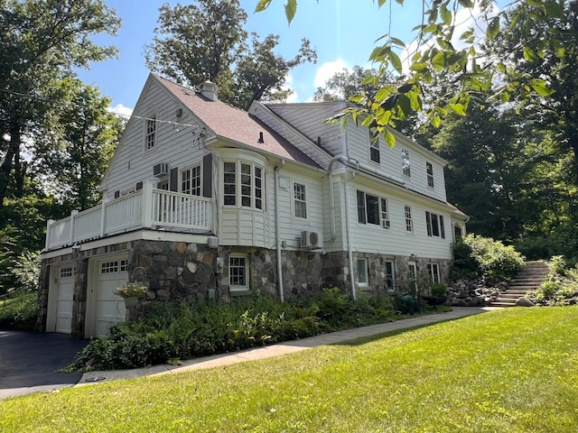 view of side of property featuring a garage and a lawn