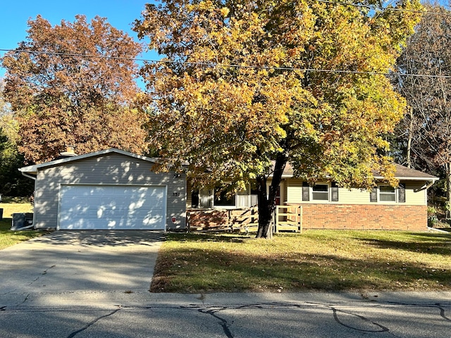 view of property hidden behind natural elements with a front yard and a garage