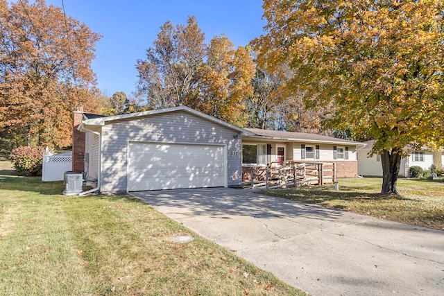 single story home featuring cooling unit, a front yard, and a garage