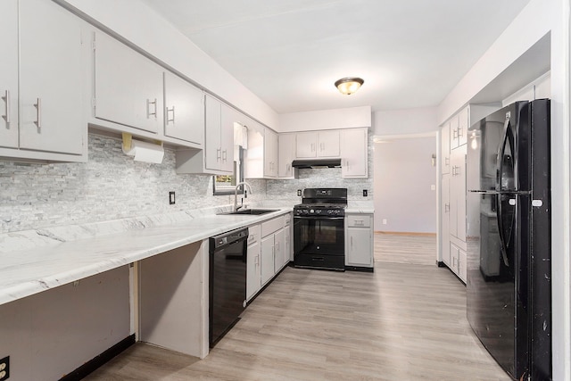 kitchen featuring light hardwood / wood-style floors, black appliances, sink, and backsplash