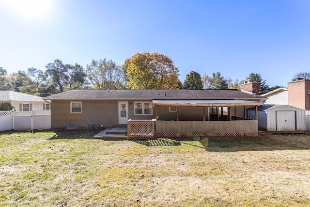 view of front of home with a front yard, a storage unit, and a deck