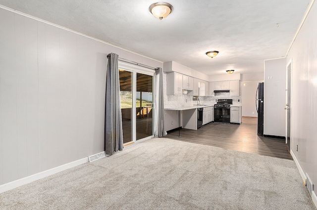 kitchen featuring white cabinets, dark hardwood / wood-style flooring, backsplash, black appliances, and sink