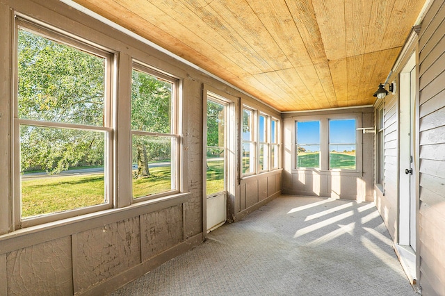 unfurnished sunroom featuring wooden ceiling and a wealth of natural light