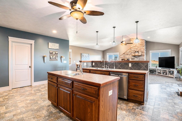 kitchen with vaulted ceiling, an island with sink, sink, and dishwasher