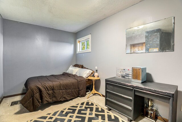 carpeted bedroom featuring a textured ceiling