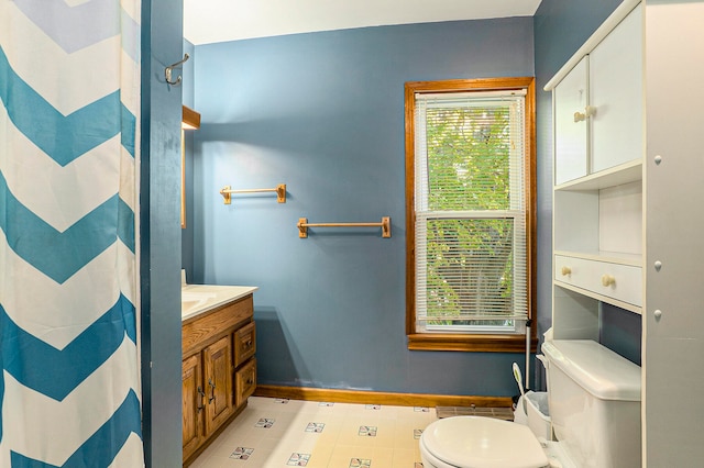 bathroom with curtained shower, plenty of natural light, vanity, and toilet