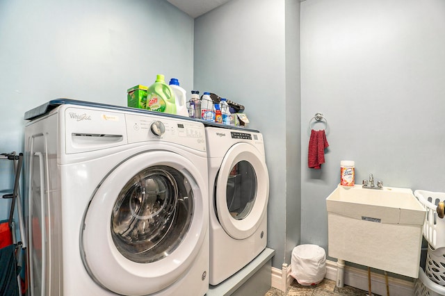 clothes washing area featuring sink and washing machine and clothes dryer