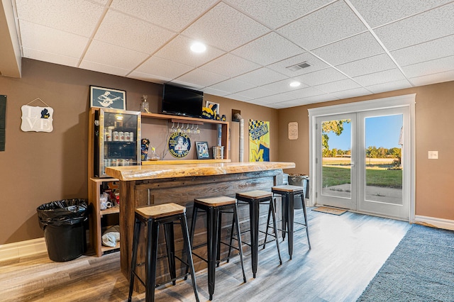 bar featuring hardwood / wood-style flooring and a paneled ceiling