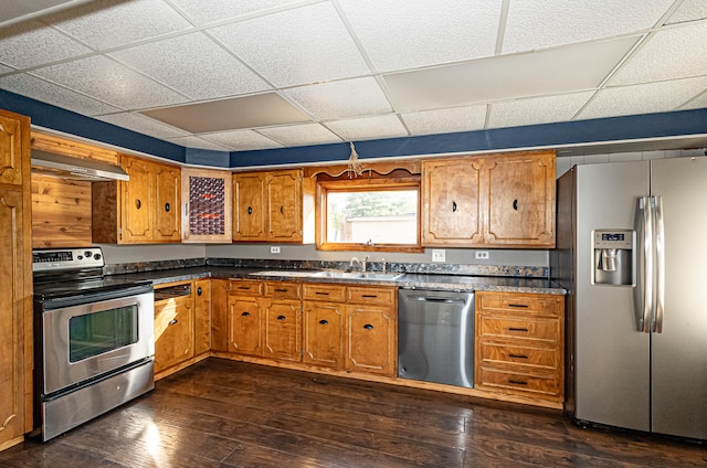 kitchen with dark wood-type flooring, stainless steel appliances, a drop ceiling, sink, and extractor fan