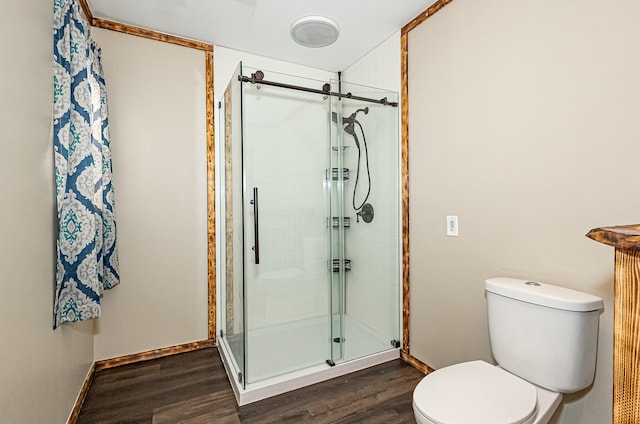 bathroom featuring walk in shower, toilet, and wood-type flooring