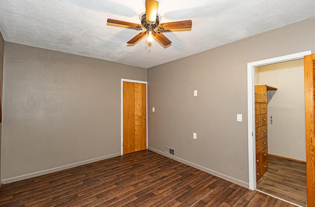 unfurnished room featuring ceiling fan and dark hardwood / wood-style flooring