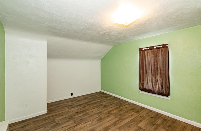 bonus room featuring a textured ceiling, lofted ceiling, and dark hardwood / wood-style flooring