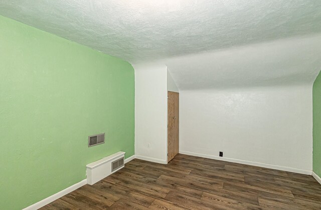 interior space featuring a textured ceiling and dark hardwood / wood-style floors