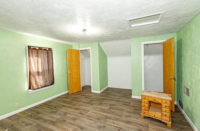 unfurnished bedroom featuring a textured ceiling, dark wood-type flooring, and a closet