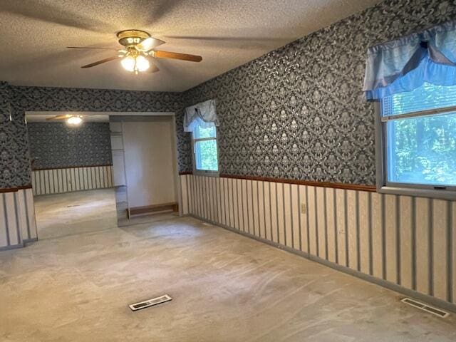 empty room with a textured ceiling and ceiling fan