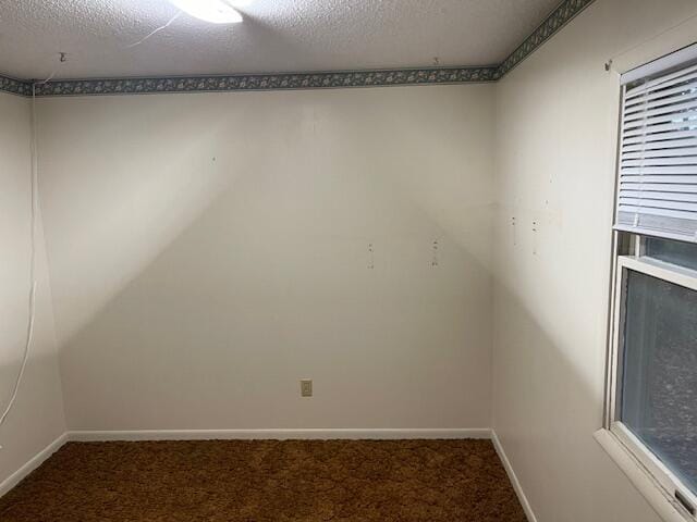 carpeted empty room featuring a textured ceiling