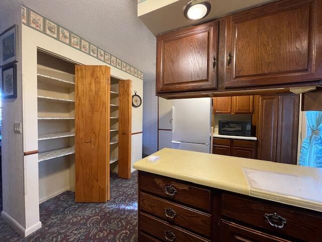 kitchen featuring a textured ceiling and white refrigerator