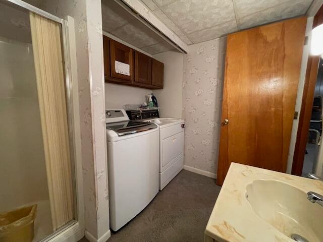 laundry area with cabinets, dark carpet, sink, and washing machine and clothes dryer