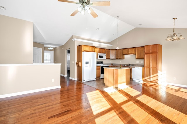 kitchen with light hardwood / wood-style flooring, white appliances, a center island, and hanging light fixtures